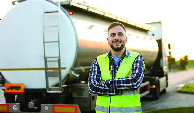 Hauling services driver standing by its hauling truck, using the MobiWork hauling services software solution