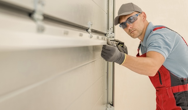 Technician repairing a garage door using the MobiWork locksmith & garage door services software solution